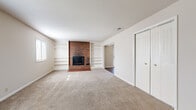 Located at 3112 Heritage Ct in Manhattan, Kansas, this single-story, 3-bedroom, 1-bathroom home offers a well-organized layout across a comfortably sized floor plan. The living room serves as a central gathering space and is defined by a striking floor-to-ceiling brick fireplace flanked by built-in white shelving units on both sides — a standout architectural feature that adds both character and functional storage. Neutral carpet covers the living room floor, contributing to a warm, understated ambiance.

The kitchen features warm wood cabinetry, tile backsplash, white appliances including a range and dishwasher, and a pendant light fixture. It connects directly to the dining room, which opens to an adjacent space via a wide doorway and is fitted with a ceiling fan and wood-look flooring, allowing for a natural flow between the two areas.

The three bedrooms are carpeted and offer closet storage, including a bifold-door closet visible in one of the rooms. Each bedroom provides a quiet, neutral setting with natural light from windows. The hallways connect the rooms efficiently throughout the single-level layout. The bathroom includes a walk-in shower with chrome fixtures. Overall, the home presents a functional and cohesive design with a mix of carpet and hardwood-style flooring.