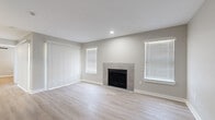 This well-appointed 2-bedroom, 2-bathroom residence is thoughtfully laid out on a single floor, offering a clean, modern aesthetic throughout. The open living room serves as the heart of the home, anchored by a tile-surround fireplace and bathed in natural light from multiple windows dressed with horizontal blinds. Light-toned wood-style flooring runs seamlessly throughout, enhancing the bright and airy atmosphere.

The galley-style kitchen is efficiently designed with gray shaker cabinetry, quartz countertops, a stainless steel sink, and a full suite of stainless steel appliances, including a refrigerator, range, microwave, and dishwasher. Both bedrooms are generously sized, each featuring ceiling fans with light fixtures and wood-style flooring. The primary bedroom includes access to a dedicated walk-in closet outfitted with built-in shelving and hanging rods. A second bedroom offers a bright window and convenient door access.

The bathrooms are tastefully finished with gray shaker vanities, quartz countertops, modern light fixtures, and framed mirrors. A hallway connects the living spaces to the private quarters, completing the functional and cohesive floor plan. The overall design presents a fresh, neutral palette ideal for comfortable everyday living.