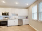Located at 816 Addicks Howell Rd in Houston, TX, this efficiently designed single-floor unit offers a thoughtful layout that maximizes every square foot. The open-concept kitchen, dining, and living area serves as the heart of the home, featuring light wood-look flooring, recessed lighting, and ceiling fans that create a bright and airy atmosphere. The kitchen is well-appointed with crisp white shaker cabinetry, granite countertops, a classic subway tile backsplash, stainless steel appliances including a range, microwave, dishwasher, and refrigerator, complemented by a single-basin sink beneath a window that brings in natural light. A welcoming entrance leads into a clean hallway lined with white panel doors providing access to two closets, a laundry area, and additional rooms. The carpeted rooms offer a comfortable, quiet retreat, each equipped with ceiling fans and dedicated closet space. The full bathroom is finished with wood-look flooring, a granite-topped white vanity, a large mirror, and a glass-enclosed shower. Neutral tones and clean lines are carried consistently throughout, lending the space a modern, move-in-ready appeal.