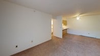 Located at 1701 Bond St in Niles, Michigan, this single-floor unit offers a practical and comfortable layout designed for everyday living. The living area is generously sized, featuring neutral-toned carpet and a ceiling fan with integrated lighting, creating a bright and airy atmosphere. A pass-through kitchen connects seamlessly to the living space, outfitted with white cabinetry trimmed in warm wood tones, ample counter space, a refrigerator, dishwasher, and durable wood-look flooring that adds a clean, modern touch. The bedrooms are well-proportioned, each featuring carpeted floors, baseboard heating, and windows that allow natural light and views of surrounding greenery. One bedroom is notably equipped with dual closets, providing substantial storage capacity. The full bathroom includes a vanity with a white countertop and single sink, a toilet, tub-shower combination, and matching wood-look flooring consistent with the kitchen. Throughout the unit, neutral wall tones and straightforward finishes create a clean, move-in-ready environment. Baseboard heating is present in multiple rooms, ensuring consistent warmth throughout. The entry area provides convenient access to both the main living space and adjoining rooms, rounding out this functional and well-organized floor plan.