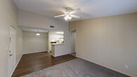 This single-story residence in Robertsdale, Alabama offers a well-organized layout featuring two bedrooms and two full bathrooms. The living area serves as the central hub of the home, featuring plush carpeting, a ceiling fan with integrated lighting, and French doors that invite natural light and provide outdoor access. An open pass-through connects the living space to the kitchen, enhancing the sense of openness between the two areas.

The galley-style kitchen is outfitted with white cabinetry, white appliances including a range and refrigerator, a double-basin sink, and ample counter space. Wood-look vinyl flooring runs through the kitchen and extends into the hallway, providing durability in high-traffic areas. A pantry or storage closet is accessible directly from the kitchen.

A hallway leads to both bedrooms, each finished with soft carpeting and ceiling fans. The bedrooms feature windows with blinds, allowing for natural light while maintaining privacy. Both full bathrooms are functionally appointed with white vanity cabinetry, a mirror, and a tub-shower combination set against neutral, warm-toned walls and wood-look flooring. Textured ceilings are consistent throughout the unit, contributing to a cohesive, understated aesthetic.