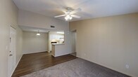 This single-story residence in Robertsdale, Alabama offers a well-organized layout featuring two bedrooms and two full bathrooms. The living area serves as the central hub of the home, featuring plush carpeting, a ceiling fan with integrated lighting, and French doors that invite natural light and provide outdoor access. An open pass-through connects the living space to the kitchen, enhancing the sense of openness between the two areas.

The galley-style kitchen is outfitted with white cabinetry, white appliances including a range and refrigerator, a double-basin sink, and ample counter space. Wood-look vinyl flooring runs through the kitchen and extends into the hallway, providing durability in high-traffic areas. A pantry or storage closet is accessible directly from the kitchen.

A hallway leads to both bedrooms, each finished with soft carpeting and ceiling fans. The bedrooms feature windows with blinds, allowing for natural light while maintaining privacy. Both full bathrooms are functionally appointed with white vanity cabinetry, a mirror, and a tub-shower combination set against neutral, warm-toned walls and wood-look flooring. Textured ceilings are consistent throughout the unit, contributing to a cohesive, understated aesthetic.