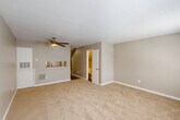 Located in Metairie, Louisiana, this two-story, two-bedroom, two-bathroom home offers a practical and well-organized layout spread across two floors. The entry level features a hallway with hardwood-style flooring that connects to the kitchen and main living areas. The kitchen is equipped with warm wooden cabinetry, granite countertops, a mosaic tile backsplash, and white appliances, offering a compact yet efficient cooking space. A pass-through window opens toward the living area, which is carpeted and includes a ceiling fan, providing a comfortable and open feel. A full bathroom on the lower level features a vessel sink, granite vanity, and a tub-shower combination with tiled surround. Upstairs, the two bedrooms are carpeted and each equipped with ceiling fans and natural light from windows. The primary bedroom is generously sized and includes closet space, while the second bedroom offers a similar layout with ample room. The upper-level bathroom mirrors the downstairs bath with a vessel sink set on a granite vanity and hardwood-style flooring. Textured ceilings are present throughout, and neutral wall tones give the home a clean, move-in-ready appearance. A carpeted staircase connects the two floors seamlessly.