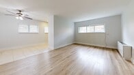 Located at 6451 Oxford Ave in Philadelphia's 19111 zip code, this single-floor, 2-bedroom, 1-bathroom unit offers a clean and functional layout finished with consistent light wood-tone flooring throughout the living areas and bedrooms. The interior is painted in soft neutral gray tones, creating a bright, cohesive atmosphere across the space.

The open living area benefits from multiple windows that allow natural light to fill the room, with views of the surrounding neighborhood. A hallway connects the main living space to the bedrooms, providing a logical and efficient floor plan.

The primary bedroom is generously sized and features a built-in closet with louvered bifold doors, offering practical storage. The second bedroom is well-proportioned with a window providing natural light and neighborhood views.

The kitchen is equipped with rich dark wood cabinetry, light countertops, a tile backsplash, and a stainless steel gas range, with tile flooring that distinguishes it from the rest of the unit.

The bathroom is finished with large-format beige wall tiles, an accent mosaic border, a full soaking tub, and tile flooring, giving it a clean and classic look.

A wall-mounted HVAC unit is present in one of the rooms, ensuring year-round climate control. Overall, the unit presents a tidy, move-in-ready feel with updated finishes throughout.