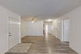 Located at 102 Stonecrest Ln in Gaffney, South Carolina, this single-story, three-bedroom, two-bathroom home offers a straightforward and functional layout. The living room serves as the central gathering space, featuring wood-look laminate flooring, a ceiling fan, and tile accents near the entry, creating a welcoming and easy-to-maintain environment. Natural light filters in through windows with blinds, lending a bright and airy feel to the open area. A door provides direct outdoor access from the living space. The kitchen is equipped with warm oak cabinetry — both upper and lower — light countertops, a white range, and a refrigerator, all set on tile flooring for practicality. The three bedrooms continue the wood-look flooring theme and are finished with clean white walls, offering versatile spaces for rest or use as a home office. The primary bedroom is comfortably sized with ample room for furnishings. Both bathrooms feature tile flooring, with one including a floating wood vanity, wall-mounted lighting, and a tub/shower combo, while the other offers a full soaking tub. This home presents a clean, move-in-ready interior with a consistent, neutral palette throughout.