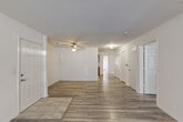 Located at 102 Stonecrest Ln in Gaffney, South Carolina, this single-story, three-bedroom, two-bathroom home offers a straightforward and functional layout. The living room serves as the central gathering space, featuring wood-look laminate flooring, a ceiling fan, and tile accents near the entry, creating a welcoming and easy-to-maintain environment. Natural light filters in through windows with blinds, lending a bright and airy feel to the open area. A door provides direct outdoor access from the living space. The kitchen is equipped with warm oak cabinetry — both upper and lower — light countertops, a white range, and a refrigerator, all set on tile flooring for practicality. The three bedrooms continue the wood-look flooring theme and are finished with clean white walls, offering versatile spaces for rest or use as a home office. The primary bedroom is comfortably sized with ample room for furnishings. Both bathrooms feature tile flooring, with one including a floating wood vanity, wall-mounted lighting, and a tub/shower combo, while the other offers a full soaking tub. This home presents a clean, move-in-ready interior with a consistent, neutral palette throughout.