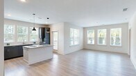 Located at 12801 Lucks Lane in Midlothian, VA, this well-appointed 2-bedroom, 2-bathroom residence offers a thoughtfully designed single-floor layout with modern finishes throughout. The open-concept living and kitchen area serves as the heart of the home, showcasing light wood-look flooring, crisp white walls, and abundant natural light from multiple windows. The kitchen is a standout feature, equipped with sleek gray cabinetry, granite countertops, stainless steel appliances including a refrigerator, electric range, and microwave, a white subway tile backsplash, and a central island with pendant lighting overhead — ideal for both cooking and casual dining. The spacious living area flows seamlessly from the kitchen, offering an open and airy feel. Both bedrooms are generously sized, featuring plush carpeting, ceiling fans, and windows with outdoor views of lush greenery. The primary bedroom includes its own en-suite bathroom, appointed with a granite-topped vanity, modern cabinetry, and stylish light fixtures. A second full bathroom serves the additional bedroom. Two closets provide ample storage. The clean, contemporary aesthetic and cohesive design make this residence a comfortable and functional home in the heart of Midlothian.