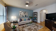 Located in Houston's Braeswood neighborhood, this 2-bedroom, 4-bathroom residence offers a refined single-story layout distinguished by elegant architectural details and quality finishes throughout. An arched entryway leads into the inviting living room, where hardwood-style flooring, crown molding, a ceiling fan, and a striking blue accent wall create a warm yet sophisticated ambiance. Large windows allow abundant natural light to fill the space. The adjacent dining area features additional oversized windows with views of surrounding greenery, reinforcing a connection to the outdoors. The kitchen is well-equipped with warm wood cabinetry, granite-style countertops, and black appliances, and opens to a charming built-in desk nook. The generously sized primary bedroom features plush carpeting, a ceiling fan, and direct access to a private en-suite bathroom complete with separate soaking tub, glass-enclosed shower, and tile surround. The second bedroom is equally comfortable, also with carpet and convenient bathroom access. Two walk-in closets with wire shelving systems provide ample storage throughout. With four bathrooms serving the home, this residence offers exceptional functionality alongside its stylish, cohesive design.