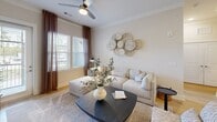Located at 2200 Pooler Parkway in Pooler, Georgia, this well-appointed 2-bedroom, 2-bathroom residence offers a clean, contemporary aesthetic across a single thoughtfully laid-out floor. Light hardwood flooring flows throughout, lending warmth and continuity to every room.

The kitchen is a standout feature, combining white upper cabinetry with natural wood lower cabinets, a marble-style tile backsplash, dark granite countertops, and stainless steel appliances. A peninsula island with seating provides additional prep space and casual dining. A built-in wine rack adds a distinctive touch.

The living room is bright and welcoming, with large windows dressed in floor-length curtains that invite natural light. A ceiling fan overhead and neutral-toned walls create a relaxed, airy atmosphere.

The primary bedroom is generously sized with large windows offering outdoor views, a ceiling fan, and access to a well-organized walk-in closet with built-in shelving. Its en-suite bathroom features a glass-enclosed shower, wood-toned vanity, and light wood flooring. The second bedroom maintains the same bright, neutral palette. The second bathroom mirrors the refined simplicity found throughout the home. A private balcony completes this residence, offering an outdoor retreat.