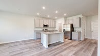 Located at 2920 Florence Drive in Gainesville, GA, this two-story home offers a well-designed layout spread across two floors. The main level features an open-concept kitchen and living area finished with light luxury vinyl plank flooring throughout. The kitchen is appointed with granite countertops, soft gray shaker-style cabinetry, stainless steel appliances, and a central island with a built-in sink — ideal for both cooking and entertaining. A pantry provides additional storage, and the attached garage offers convenient parking and utility access. The upper floor houses all three bedrooms, three full bathrooms, a dedicated laundry room, and hallway connections. The spacious primary bedroom features a tray ceiling, ceiling fan, and a large window that invites natural light, complemented by a walk-in closet with wire shelving and a natural light window. The secondary bedrooms are bright and well-proportioned with large windows and consistent flooring. Each bathroom is finished with granite-topped gray vanities, tub-shower combinations, and clean white surrounds. The laundry room includes washer/dryer hookups, wire shelving, and a utility drain. Throughout the home, a neutral color palette and consistent modern finishes create a cohesive, move-in-ready atmosphere.