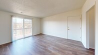 Located at 1307 W Lincoln Hwy in DeKalb, IL, this 2-bedroom, 2-bathroom single-floor unit offers a practical and comfortable layout. The living room features durable hardwood-style flooring, a textured ceiling, and a sliding glass door that opens to a private balcony with outdoor views, allowing natural light to fill the space. The kitchen is well-equipped with warm wood cabinetry, granite-style countertops, a double sink, and black appliances including a gas range, dishwasher, and refrigerator. A secondary door in the kitchen provides additional outdoor access alongside a window that brings in further natural light. Both bedrooms are finished with plush carpeting and feature built-in closets with bifold doors, offering practical storage solutions. The primary bedroom is a comfortable size with access to the hallway connecting the rest of the unit. Two bathrooms serve the residence, one of which includes a full tub and shower combination with built-in shelving and chrome fixtures. The unit also includes a hallway and dedicated closet space for added convenience. Textured ceilings are consistent throughout, and the clean, neutral color palette creates a bright and welcoming ambiance throughout the home.