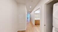 Located on the seventh floor at 1100 Boylston Ave in Seattle's Capitol Hill neighborhood, this one-bedroom, one-bathroom unit offers a thoughtfully designed layout with modern finishes throughout. Light hardwood flooring runs continuously across the entire space, creating a warm and cohesive feel from room to room.

The galley-style kitchen is outfitted with wood-toned cabinetry, white quartz countertops, a subway tile backsplash, stainless steel appliances, and recessed lighting — a clean and functional design ideal for everyday use. A sliding barn-style door adds a contemporary touch at the kitchen entrance.

The living area is bright and open, featuring large sliding glass doors that lead to a private balcony with city views, allowing natural light to fill the space. A wall-mounted mini-split unit ensures comfortable climate control year-round.

The bedroom is a well-proportioned retreat with its own balcony access, a high clerestory window for added natural light, and a dedicated walk-in closet with wrap-around hanging rods providing generous storage.

The bathroom features a long wood-grain vanity with a white countertop, a large mirror, and a tiled shower area. The hallway connecting each room is lined with recessed lighting and reinforces the unit's clean, modern aesthetic.
