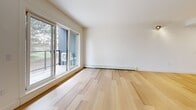 This well-appointed 2-bedroom, 2-bathroom unit in East Hants, Nova Scotia, offers a thoughtfully designed single-level layout with modern finishes throughout. Light hardwood flooring flows seamlessly across the main living areas, creating a warm, cohesive aesthetic complemented by clean white walls and recessed lighting.

The open-concept kitchen and living area forms the heart of the unit. The kitchen features a central island with an undermount sink, white lower cabinetry, warm wood-toned upper cabinets, a glass backsplash, and a full suite of stainless steel appliances including a refrigerator, range, and built-in microwave. The adjacent living area is bright and spacious, with a sliding glass door that opens onto a private outdoor deck with outdoor seating.

Both bedrooms are generously sized, featuring the same light hardwood flooring, large windows that invite natural light and treetop views, and baseboard heating. A wall-mounted mini-split unit provides additional climate control in the living space.

The two bathrooms are finished with large-format light tiles, a glass-enclosed shower, and a wood-accented vanity with a white countertop. A dedicated laundry room houses a stacked Whirlpool washer and dryer for added convenience. A closet provides additional storage, rounding out this clean, contemporary residence.