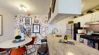 Located at 1717 Canvasback Lane in Columbus, Ohio, this single-floor residence offers a thoughtfully designed layout with a warm, eclectic aesthetic. The open-concept kitchen serves as a central gathering point, featuring granite countertops, a breakfast bar with seating, white cabinetry, stainless steel appliances, and a distinctive mosaic tile accent wall that adds bold visual character. Wood-look flooring flows through the main living areas, anchoring a living room that is spacious and inviting, with natural light filtering in through large windows dressed with patterned curtains. The bedrooms are generously sized with plush carpet, ample closet space, and windows that allow in comfortable natural light. Each room features tasteful accent walls and curated décor, contributing to a cohesive and lived-in feel. The bathrooms are well-appointed with white vanities, large framed mirrors, and tub-shower combinations with tile surrounds. Throughout the home, textured ceilings, neutral base tones, and layered furnishings create a cozy yet stylish ambiance. The overall design balances functionality with personality, making this Columbus residence a comfortable and visually engaging space.
