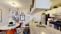 Located at 1717 Canvasback Lane in Columbus, Ohio, this single-floor residence offers a thoughtfully designed layout with a warm, eclectic aesthetic. The open-concept kitchen serves as a central gathering point, featuring granite countertops, a breakfast bar with seating, white cabinetry, stainless steel appliances, and a distinctive mosaic tile accent wall that adds bold visual character. Wood-look flooring flows through the main living areas, anchoring a living room that is spacious and inviting, with natural light filtering in through large windows dressed with patterned curtains. The bedrooms are generously sized with plush carpet, ample closet space, and windows that allow in comfortable natural light. Each room features tasteful accent walls and curated décor, contributing to a cohesive and lived-in feel. The bathrooms are well-appointed with white vanities, large framed mirrors, and tub-shower combinations with tile surrounds. Throughout the home, textured ceilings, neutral base tones, and layered furnishings create a cozy yet stylish ambiance. The overall design balances functionality with personality, making this Columbus residence a comfortable and visually engaging space.