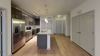 This single-story, two-bedroom, two-bathroom residence offers a thoughtfully designed layout with contemporary finishes throughout. The kitchen serves as a central highlight, featuring gray shaker-style cabinetry, a white subway tile backsplash, stainless steel appliances, and a granite-topped island with an undermount sink and pendant lighting overhead. Track lighting further illuminates the space, which flows seamlessly into the open living area via light-toned hardwood-style flooring.

Both bedrooms are comfortably proportioned, each equipped with a ceiling fan and windows that invite natural light. One bedroom features hardwood-style flooring, while the other is finished with plush carpeting, offering a cozy atmosphere.

The primary bathroom is well-appointed with a dual-sink vanity topped in granite, dark cabinetry with brushed nickel hardware, a large wall mirror, and a glass-enclosed walk-in shower with dark tile surround. The second bathroom provides a tub-shower combination with matching dark tile surround, a granite-topped vanity, and hardwood-style flooring. Clean white walls and neutral tones throughout contribute to a bright, modern ambiance.