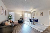 This thoughtfully designed 2-bedroom, 2-bathroom residence is laid out on a single floor, offering a practical and comfortable living arrangement. The open-concept living and dining area serves as the heart of the home, featuring durable wood-style flooring, a textured ceiling, and a ceiling fan that adds both function and character. A large sliding glass door floods the space with natural light and provides direct access to an outdoor area, while a side window further brightens the room. The kitchen is configured in a galley style, outfitted with white cabinetry, dark granite-style countertops, and black appliances, including a range and dishwasher — offering an efficient and clean workspace. The primary bedroom is a comfortable retreat with wood-style flooring, a window with blinds, and a textured ceiling. The second bedroom is equally functional and well-sized. Both bathrooms feature shower-tub combinations with tiled surrounds and wood-style flooring. The residence also includes three closets for ample storage, a dedicated laundry area, an entrance foyer, and a connecting hallway. Neutral wall tones throughout create a cohesive and move-in-ready atmosphere.