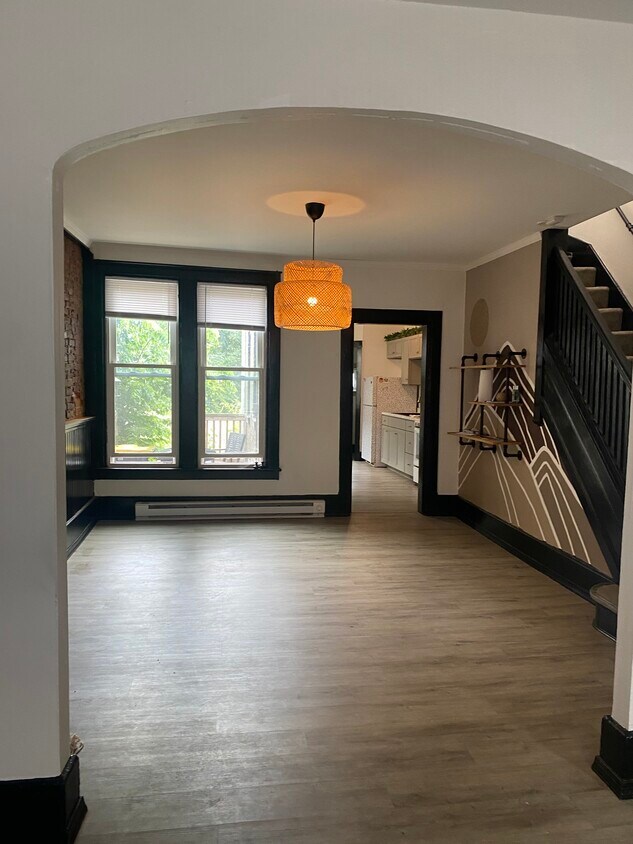 View of dining room with custom light and hand painted mural and shelving. Exposed brick throughout - 20 Conestoga St