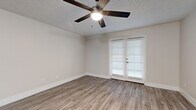 Located at 10888 N 70th St in Scottsdale, Arizona, this single-floor, 3-bedroom, 2-bathroom home offers a clean and modern living environment with thoughtfully updated finishes throughout. Wood-look laminate flooring runs consistently across all rooms, lending a cohesive and contemporary feel to the space.

The living room features a textured ceiling, a ceiling fan with light fixture, and a hallway leading to the bedrooms, creating an open and connected layout. French doors with white blinds in the primary bedroom invite natural light while providing privacy, complemented by a ceiling fan overhead. The primary bedroom includes generous closet space with built-in shelving. Secondary bedrooms also feature sliding closet doors and ceiling fans, maintaining a consistent, functional design.

The kitchen stands out with white shaker-style cabinetry, white countertops, a skylight panel for added brightness, and a full suite of stainless steel appliances including a refrigerator, dishwasher, microwave, and range. Both bathrooms are finished in crisp white tones with tub-shower combinations and wood-look flooring. The second bathroom includes a white vanity with modern hardware. Neutral wall colors and clean white trim throughout give the home a bright, move-in-ready appearance.
