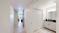 Located at 202 Green St E in Champaign, Illinois, this single-floor residence offers four bedrooms and three bathrooms within a well-designed, efficiently utilized layout. The modern kitchen is a standout feature, showcasing wood-grain cabinetry with dark granite countertops, stainless steel appliances including a French-door refrigerator, a range, and a microwave, complemented by pendant lighting and light wood-style tile flooring. Adjacent to the kitchen, the dining area benefits from large windows that invite abundant natural light and outdoor views. The living room is bright and open, with high ceilings, light hardwood-style flooring, and a clean, contemporary aesthetic. The four bedrooms are carpeted and feature mirrored sliding closet doors, with select rooms offering access to an outdoor balcony through sliding glass doors with vertical blinds. Three well-appointed bathrooms feature dark granite vanity tops, white cabinetry, tile flooring, and tub-shower combinations. A central hallway connects all areas seamlessly, and a double-door closet provides additional storage. The overall ambiance is clean, modern, and functional, making this a practical and comfortable home in the heart of Champaign.