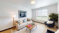 Located at 1151 32nd Ave N in Fargo, North Dakota, this single-floor unit offers a thoughtfully designed open-concept layout that seamlessly connects the kitchen, dining, and living areas. The kitchen is well-equipped with warm-toned wood cabinetry, stainless steel appliances including a refrigerator, range, and built-in microwave, complemented by grey countertops and a peninsula with bar seating beneath a stylish pendant light. Hardwood flooring anchors the kitchen and dining space, while the living area transitions to soft carpeting and features bright windows that invite natural light. The unit includes multiple bedrooms, each carpeted and finished with clean white walls, ample natural light from well-placed windows, and generous closet space. One bedroom features a walk-through closet leading directly to a full bathroom, while a second full bathroom includes a tub-shower combination, single vanity, and tile flooring. Throughout the unit, the design maintains a clean, contemporary aesthetic with neutral tones, crisp white walls, and consistent dark baseboards. The overall ambiance is bright, functional, and comfortable, making it a practical and inviting living space.