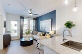 Located at 230 Bill Kennedy Way SE in Atlanta's vibrant Glenwood Park neighborhood, this well-appointed one-bedroom, one-bathroom residence offers a thoughtfully designed open-concept layout across a single floor. The kitchen serves as a central highlight, featuring two-tone cabinetry with white upper cabinets and dark lower cabinets, granite countertops, a hexagonal tile backsplash, stainless steel appliances, and pendant lighting — all flowing seamlessly into the living area. The living room is bright and welcoming, anchored by a bold blue accent wall, a ceiling fan, and large windows with outdoor views that fill the space with natural light. The bedroom continues the deep blue color palette, offering plush carpeting, ceiling fan, and generous natural light from dual windows. A walk-in closet with built-in shelving and hanging rods provides organized storage. The bathroom is clean and modern, featuring large-format tile flooring, a glass-enclosed walk-in shower, granite vanity, and crisp white finishes. Wood-look flooring extends throughout the main living areas, tying the design together. The unit also includes an in-unit laundry for added convenience, completing this polished and functional Atlanta residence.