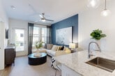Located at 230 Bill Kennedy Way SE in Atlanta's vibrant Glenwood Park neighborhood, this well-appointed one-bedroom, one-bathroom residence offers a thoughtfully designed open-concept layout across a single floor. The kitchen serves as a central highlight, featuring two-tone cabinetry with white upper cabinets and dark lower cabinets, granite countertops, a hexagonal tile backsplash, stainless steel appliances, and pendant lighting — all flowing seamlessly into the living area. The living room is bright and welcoming, anchored by a bold blue accent wall, a ceiling fan, and large windows with outdoor views that fill the space with natural light. The bedroom continues the deep blue color palette, offering plush carpeting, ceiling fan, and generous natural light from dual windows. A walk-in closet with built-in shelving and hanging rods provides organized storage. The bathroom is clean and modern, featuring large-format tile flooring, a glass-enclosed walk-in shower, granite vanity, and crisp white finishes. Wood-look flooring extends throughout the main living areas, tying the design together. The unit also includes an in-unit laundry for added convenience, completing this polished and functional Atlanta residence.