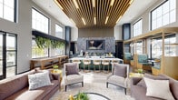 This thoughtfully designed single-floor community lounge delivers a sophisticated and welcoming atmosphere across a generously proportioned open-concept layout. The space immediately commands attention with its dramatic double-height ceilings adorned with a striking slatted wood ceiling installation, integrated with warm linear lighting that creates a bold architectural focal point. Floor-to-ceiling windows and large grid-pane glass panels flood the interior with natural light, offering views of an outdoor pool area and surrounding grounds.

At the heart of the space is an expansive kitchen and bar area featuring sleek dark cabinetry with brushed gold hardware, a waterfall-edge white quartz island, and stylish bar seating. A textured slate tile accent wall frames a mounted flat-screen display above the counter, lending an upscale, lounge-like quality. Adjacent to the kitchen, a cozy booth nook with teal upholstery and a warm wood framework offers an intimate seating option.

The lounge area features plush neutral sofas and accent chairs arranged around a circular coffee table, complemented by a vibrant large-scale mural wall in yellow, green, and grey abstract patterns. Trailing greenery cascades from elevated shelving, adding life and warmth throughout. A shuffleboard table rounds out the recreational offerings, making this a dynamic and versatile communal gathering space.