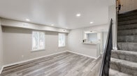 Located at 44 Blake Loop in Newport News, Virginia, this two-story home offers a clean, modern aesthetic throughout its thoughtfully updated interior. The main level features an open living and dining area finished with light gray wood-look luxury vinyl plank flooring, recessed lighting, and large windows that invite natural light. A granite-topped breakfast bar connects the living space to a well-appointed galley kitchen, which is outfitted with crisp white shaker cabinetry, granite countertops, black appliances including a range, refrigerator, and dishwasher, and a stainless steel sink beneath a window overlooking the outdoors.

Upstairs, the bedrooms are finished with neutral carpet and feature generous closet space. The primary bedroom stands out with dual closets offering ample built-in shelving and hanging rods. Additional bedrooms are equally well-proportioned, each with their own closet storage. The bathroom includes a full tub and shower combination with chrome fixtures, complementing the home's clean and neutral color palette throughout.

The overall design is consistent and cohesive, with warm greige wall tones, white trim, and modern finishes that create a bright, move-in-ready environment suited for everyday comfort.