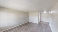 Located at 5912 Red Bluff Rd in Pasadena, TX, this single-story, one-bedroom, one-bathroom unit offers a practical and comfortable layout across a compact but well-utilized floor plan. The living room serves as the heart of the home, featuring durable wood-look laminate flooring, neutral gray-toned walls, a textured ceiling, and a large window that allows natural light to pour in while offering views of the surrounding outdoor greenery. The space flows into the kitchen, which is equipped with a coil-top electric range, a full-size refrigerator, and sage-toned upper cabinetry with an overhead ventilation hood. The bedroom is carpeted for warmth and comfort, fitted with a ceiling fan with light fixture, a window with outdoor views, and direct access to a dedicated closet with built-in shelving. The bathroom features a full tub-and-shower combination surrounded by warm beige tile, complemented by wood-look flooring. A hallway connects the rooms efficiently, and a dedicated laundry area adds everyday convenience. Throughout the unit, neutral tones, consistent finishes, and functional design create a clean and livable atmosphere well-suited for comfortable single-occupant living.