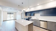 Located at 811 N Hogan St in Spokane, WA, this 2-bedroom, 1-bathroom unit offers a thoughtfully designed layout with modern finishes throughout. The kitchen is a standout feature, showcasing bold navy upper cabinetry paired with sleek gray lower cabinets, a crisp white quartz island with pendant lighting, stainless steel appliances including a range, microwave, and dishwasher, and a clean white tile backsplash. Light wood-tone flooring flows seamlessly through the open-concept kitchen and living area, creating a cohesive and contemporary feel. The living room is bright and airy, benefiting from natural light and a wall-mounted mini-split climate control system. Both bedrooms are well-proportioned, featuring light wood flooring, roller shade window treatments, and views of the surrounding Spokane neighborhood. The second bedroom includes a door to access additional spaces and offers a compact, functional layout. The bathroom is clean and modern, featuring gray cabinetry with a white quartz vanity top, a full tub-shower combo, and a large mirror with overhead lighting. Two closets provide ample storage. Recessed lighting throughout enhances the bright, contemporary ambiance of this well-appointed Spokane residence.