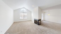 Located on Primrose Lane in Ypsilanti, Michigan, this two-story home offers a well-organized layout across two levels, with the majority of living space situated on the main floor. The open-plan living and dining area is bright and carpeted, featuring vaulted ceilings that lend an airy, spacious feel, along with a fireplace visible in the 3D overview. Natural light flows in through large windows, enhancing the welcoming ambiance throughout.

The kitchen is functionally designed with warm wood cabinetry, dark granite-style countertops, tile flooring, a double-basin stainless steel sink, and black appliances including an electric range and built-in microwave. The space flows conveniently into the living and dining areas, making it well-suited for everyday living and entertaining.

The home includes two carpeted bedrooms, each with closet access—the primary bedroom features a generous walk-in closet with wire shelving and built-in storage. Three full bathrooms are finished with tile flooring, wood vanity cabinetry, and tub-shower combinations. Additional highlights include a dedicated laundry room, a utility room, a balcony, and a spacious attached garage with drywall-finished walls. Carpeted staircases connect the levels, completing this practical and comfortable home.
