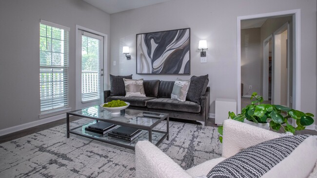 our living room features ample natural lighting and a ceiling fan, creating the perfect ambiance for your everyday retreat! - 12th and James Luxury Apartments