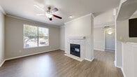 Located at 4600 Bellaire Drive South in Fort Worth, TX, this well-appointed 1-bedroom, 1-bathroom unit offers a thoughtful layout across a single floor. The open living and dining area serves as the heart of the home, highlighted by a tile-surround fireplace with a classic white mantel, crown molding, and wood-style flooring that runs throughout. A ceiling fan with light fixture adds comfort, while a large window and sliding glass door flood the space with natural light and offer views of the surrounding greenery. The kitchen is well-equipped with rich dark cabinetry, granite countertops, a subway tile backsplash, a stainless steel dishwasher, and ample storage including a dedicated pantry. The bedroom features plush carpeting, crown molding, a generous closet, and a bright window. The bathroom is elegantly finished with a wide granite-topped vanity, dark wood cabinetry, a full soaking tub with white tile surround, and wood-style flooring. An in-unit laundry room with washer and dryer adds everyday convenience. Two closets provide additional storage throughout the unit.
