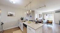 Located at 108 W North Ave in Elmhurst, IL, this well-appointed one-bedroom, two-bathroom residence offers a thoughtfully designed single-floor layout. The open-concept kitchen, dining, and living area serves as the heart of the home, featuring a granite-topped island with pendant lighting, white cabinetry, stainless steel appliances—including a French-door refrigerator and dishwasher—and durable wood-style flooring. A dedicated dining area sits adjacent to the kitchen, while the living room opens to an outdoor balcony through sliding glass doors, filling the space with natural light. The bedroom is generously sized, carpeted for comfort, and leads directly into a spacious en-suite bathroom with a granite vanity, white cabinetry, and large-format tile flooring. A second full bathroom provides added convenience for guests. Two closets offer ample storage throughout. The in-unit laundry closet houses a full-size side-by-side washer and dryer. Track and pendant lighting add a modern touch, while the neutral color palette and clean architectural lines create a cohesive, contemporary ambiance throughout this well-equipped Elmhurst residence.