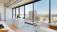 Located on the 14th floor at 222 Third Street in the heart of Detroit, this one-bedroom, one-bathroom residence offers a thoughtfully designed layout with a clean, contemporary aesthetic throughout. The open living and kitchen area is anchored by dramatic floor-to-ceiling windows that flood the space with natural light and frame stunning panoramic views of the Detroit River and the city skyline — a defining feature of this urban retreat.

The kitchen is sleek and functional, outfitted with white flat-front cabinetry, a white quartz countertop, and a full suite of stainless steel appliances including a range, over-the-range microwave, and refrigerator. Light hardwood flooring carries through the main living areas, complementing the bright, neutral palette.

The bedroom is a serene haven, benefiting from its own floor-to-ceiling window showcasing the cityscape below. Exposed industrial ductwork and a concrete ceiling lend an urban loft character, while the generous proportions allow for comfortable furnishing.

The bathroom is spa-inspired, featuring large-format tile flooring, a frameless glass walk-in shower with white subway tile, and a long floating vanity with a white stone countertop and ample storage. A hallway and dedicated closet complete the layout, adding practical storage solutions. The overall ambiance is modern, airy, and distinctly metropolitan.