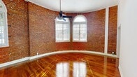 Step into a world where historic charm meets modern elegance in this captivating 720 sq ft urban retreat. The moment you enter, you're greeted by the warm glow of sunlight streaming through arched windows, dancing across gleaming hardwood floors that speak of timeless craftsmanship. The living area, a testament to architectural ingenuity, boasts exposed brick walls that curve gracefully, creating a unique circular space that's both intimate and grand.

The kitchen is a culinary artist's dream, marrying functionality with style. Navy blue lower cabinets provide a striking contrast to crisp white upper units, while a subway tile backsplash adds a touch of metropolitan sophistication. State-of-the-art stainless steel appliances stand ready for your gourmet adventures.

The bedroom, a generous 190 sq ft sanctuary, features elegant arched windows that flood the space with natural light, creating an airy, tranquil atmosphere. Multiple closets throughout the apartment offer abundant storage, ensuring a clutter-free living experience.

The bathroom, a vision in white, offers a serene spa-like retreat with its clean lines and modern fixtures. A large window allows natural light to brighten the space, while providing privacy with frosted glass.

This home is more than just a living space; it's an invitation to a lifestyle of urban sophistication and comfort. Whether you're hosting friends in the unique circular living room or enjoying a quiet evening in your sun-drenched bedroom, this apartment offers the perfect backdrop for creating lasting memories. Welcome to your new chapter in Los Angeles living.