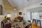 Located in the heart of New Orleans' Central Business District, this well-appointed one-bedroom, one-bathroom unit offers a smart and functional layout across a single floor. The kitchen is a standout feature, showcasing rich wood cabinetry with sleek hardware, white quartz countertops, a subway tile backsplash, stainless steel appliances, and a central peninsula that connects seamlessly to the open-concept dining and living area. The combined dining and living space is warm and inviting, with light wood flooring, a ceiling fan, and natural light streaming through large windows framed by bold red curtains. The living area accommodates comfortable seating and a defined dining zone. The bedroom offers a tranquil retreat with hardwood floors, large windows with light-filtering curtains, and a ceiling fan. The bathroom features tile flooring, a glass-enclosed shower, and warm wood vanity cabinetry. Additional spaces include a closet, a bonus room, and in-unit laundry, enhancing everyday convenience. The unit also includes a dedicated entryway off the kitchen, completing a practical and cohesive floor plan suited for urban living in one of New Orleans' most vibrant neighborhoods.