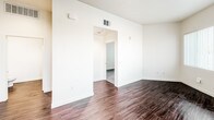 Located at 3050 Mission Inn Ave in Riverside, California, this single-floor unit offers a clean, modern aesthetic throughout. Rich, dark hardwood-style flooring flows seamlessly through the main living areas, creating a warm and cohesive feel across the space.

The open living area is bright and welcoming, featuring multiple windows fitted with vertical blinds that invite generous natural light while offering views of the surrounding neighborhood, including mature palm trees. The layout connects naturally to the kitchen, which is outfitted with sleek gray cabinetry, dark countertops, and a full suite of stainless steel appliances including a refrigerator, electric range, over-the-range microwave, and dishwasher — offering both functionality and a contemporary aesthetic.

A dedicated bedroom provides a quieter retreat, carpeted for comfort, with a window framing outdoor greenery and a closet for ample storage. The space also includes a well-appointed bathroom featuring wood-style flooring, a white-tiled shower and tub surround, and crisp white walls that contribute to a clean, refreshed feel.

Throughout the unit, neutral wall tones, modern fixtures, and consistent finishes create a cohesive and move-in-ready environment well-suited for comfortable everyday living in the heart of Riverside.