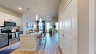 Located at 18313 FM 1093 in Richmond, TX, this thoughtfully designed one-bedroom, one-bathroom residence offers a comfortable and modern living experience across a single floor. Light-toned wood-style flooring flows seamlessly throughout the space, lending warmth and cohesion to every room.

The open-concept kitchen and living area forms the heart of the home. The kitchen is outfitted with stainless steel appliances, including a full-size refrigerator, range, microwave, and dishwasher. Two-tone cabinetry in white and slate gray pairs with granite countertops and a functional island with a single-basin sink, offering both style and practicality. Pendant lighting accents the space above.

The living room receives abundant natural light through large windows dressed with shutters and drapes, and features a ceiling fan overhead. A private exterior door adds convenience and connectivity to the outdoors.

The bedroom is a serene retreat highlighted by a teal accent wall, large windows, a ceiling fan, and direct access to the walk-in closet, which features built-in shelving and hanging rods for generous storage.

The bathroom impresses with a dual-sink granite vanity, framed mirrors, and a full soaking tub with tile surround, completing this well-appointed residence.