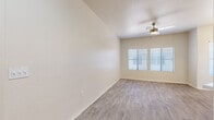 Located at 7611 S 36th Way in Phoenix, AZ, this single-story 1-bedroom, 1-bathroom home offers a well-designed layout across a comfortable footprint. Light-toned wood-look flooring runs throughout, creating a cohesive and easy-to-maintain interior. The living room is a bright, open space featuring a ceiling fan and wide windows with blinds that allow abundant natural light while providing privacy. The bedroom is a well-proportioned retreat, also equipped with a ceiling fan and a large window overlooking the outdoors. A spacious walk-in closet off the bedroom provides generous built-in shelving and hanging rods on multiple walls, offering excellent storage capacity. The kitchen is outfitted with white shaker-style cabinetry, stainless steel appliances including a refrigerator and range, white countertops, and a marble-style tile backsplash — a clean, modern aesthetic. The bathroom features a white vanity with mirror, a tiled tub-shower combination, and wood-look flooring that extends into the hallway. A dedicated laundry area houses a full-size washer and dryer alongside the water heater, adding everyday convenience. The overall ambiance is clean, neutral, and move-in ready.