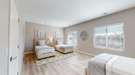 Located at 1470 S Santa Fe Ave in Vista, CA, this single-floor space centers around a generously sized bedroom designed to accommodate multiple occupants comfortably. The room is finished with light-toned luxury vinyl plank flooring that runs throughout, contributing to a clean, cohesive aesthetic. Neutral warm-gray walls provide a calming backdrop, complemented by recessed lighting that ensures consistent illumination across the space.

Multiple windows fitted with white horizontal blinds line the walls, inviting abundant natural light and offering views of the surrounding outdoor environment. The room provides ample floor space to house several beds without feeling crowded, making it well-suited for shared living arrangements. Decorative wall art in soft coastal tones adds a welcoming, curated touch to the interior.

Storage is addressed through a dedicated walk-in closet, accessible directly from the bedroom, featuring built-in shelving and hanging rods. A second door leads to an additional room or hallway, further enhancing the functional layout. The overall ambiance of the space is bright, airy, and thoughtfully appointed, reflecting a modern design sensibility suited to comfortable, practical living.