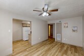 Located at 2615 El Toro Drive in Huntsville, Texas, this single-story 2-bedroom, 1-bathroom residence offers a functional and thoughtfully updated layout. The living room serves as the heart of the home, featuring light wood-look flooring, a ceiling fan with light fixture, and a textured ceiling. A wide pass-through opening connects the living area to the kitchen, promoting an open, airy feel. The kitchen is well-equipped with granite countertops, a tile backsplash, ample cabinetry, and white appliances including an electric range, microwave, and refrigerator. A hallway leads to both bedrooms and the shared bathroom. The spacious primary bedroom offers plush carpeting, a ceiling fan, natural light from a window, and access to a closet. The second bedroom mirrors the primary in comfort, also featuring carpet, a ceiling fan, and a window. The full bathroom impresses with granite countertops, a vessel sink vanity, and a tub-shower combo accented by marble-style surround tile. Two closets provide ample storage throughout. The neutral color palette and updated finishes create a clean, move-in-ready atmosphere throughout this efficiently designed home.