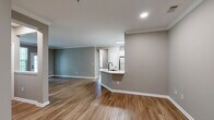 Located in Harper's Crossing in Langhorne, PA, this well-appointed 3-bedroom, 2-bathroom single-floor home offers a thoughtfully designed layout with modern finishes throughout. The open-concept kitchen and living area serves as the heart of the home, featuring white shaker cabinets, quartz countertops with a waterfall island, stainless steel appliances including a gas range and refrigerator, and a matte black undermount sink — all complemented by light hardwood-style flooring. The living room is generously sized, with warm neutral-toned walls, crown molding, and large windows and a glass door that flood the space with natural light and provide outdoor views. The bedrooms are carpeted and well-lit by multiple windows, including a spacious primary bedroom with its own walk-in closet equipped with wire shelving systems. A second carpeted walk-in closet adds additional storage. Both bathrooms are finished with white vanities featuring black hardware, light wood-style flooring, and full tub-shower combinations with tiled surrounds. Neutral greige tones carry throughout, creating a cohesive and clean aesthetic across the entire home.
