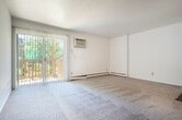 This well-organized single-floor residence offers two bedrooms, one full bathroom, and a practical layout across a compact but efficient footprint. The living area is carpeted and bathed in natural light from a sliding glass door that opens onto a private balcony, offering pleasant outdoor views of surrounding greenery. White panel walls and neutral tones give the space a clean, bright aesthetic throughout.

The galley-style kitchen is efficiently designed with warm wood cabinetry lining both sides, dark laminate countertops, tile flooring, and a full suite of appliances including a dishwasher and refrigerator. A connecting hallway links the kitchen to the rest of the unit, including two closets for additional storage.

Both bedrooms are carpeted and feature white walls, with windows that invite natural light and views of mature trees. The primary bedroom offers a dedicated closet with built-in shelving and rod, while both rooms include baseboard heating units for year-round comfort. Each bedroom connects conveniently to the main hallway.

The full bathroom is finished with tile flooring in a warm stone pattern, a single-sink vanity with wood cabinetry, a white countertop, and a full tub-shower combination. The overall layout is straightforward and functional, making efficient use of the available space throughout.