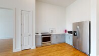 Located at 5126 Peachtree Blvd in Chamblee, Georgia, this single-floor unit offers a clean, contemporary design with an open layout and consistent hardwood flooring throughout. The open-concept kitchen is a central highlight, featuring a large white quartz island with an integrated sink, two-tone cabinetry with upper white and lower gray units, white subway tile backsplash, and a full suite of stainless steel appliances including a range, over-the-range microwave, and French door refrigerator. The kitchen flows seamlessly into the main living area, which is bathed in natural light from expansive steel-framed floor-to-ceiling windows and a glass door that opens to the outdoors. The generously sized bedrooms continue the hardwood flooring and feature large steel-framed windows with views of the surrounding greenery, as well as ceiling fans for added comfort. The bathroom is finished with white subway tile in the tub surround, a white quartz vanity with gray cabinetry, and access to a walk-in closet with open shelving. Recessed lighting, tall ceilings, and a crisp white palette give the entire space a bright, airy, and modern ambiance throughout.