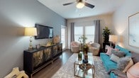 This single-story, one-bedroom, one-bathroom residence offers a thoughtfully designed layout that maximizes its compact footprint. The living area features hardwood-style flooring, a ceiling fan, and multiple windows dressed with blinds and curtain panels that allow natural light to fill the space. The room comfortably accommodates a seating arrangement, making it a practical yet inviting area for everyday use.

The kitchen is equipped with rich dark-espresso cabinetry, granite-style countertops, a tile backsplash with a mosaic pattern, and a peninsula that provides additional workspace and casual dining potential. Recessed lighting and wood-style flooring complete the functional, well-finished design.

The bedroom is carpeted for comfort and includes a ceiling fan, a walk-in closet, and windows with natural light. The room offers ample space for full-sized furniture and connects visually to the living area through an open doorway, enhancing the sense of flow throughout the unit.

The bathroom features dark cabinetry matching the kitchen, a granite-style vanity top, a tub-shower combination with tile surround, and wood-style flooring. The cohesive design elements carried throughout the unit give the space a unified, polished aesthetic overall.