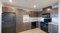 Located at 1110 Shady Brook Ln in West Haven, Utah, this well-designed one-bedroom, one-bathroom unit offers a smart and functional single-floor layout. The open-concept living and kitchen area is bright and welcoming, with light wood-style flooring, recessed lighting, and a ceiling fan that enhance the airy feel. Natural light filters in through windows overlooking the outdoors, adding to the unit's clean, modern ambiance.

The kitchen is a standout feature, outfitted with rich dark brown cabinetry offering ample upper and lower storage, light granite-style countertops, and a full suite of black appliances including a refrigerator, electric range with over-the-range microwave, and dishwasher. The layout makes efficient use of the available space, providing a practical cooking environment.

The bedroom is a comfortable, carpeted retreat with a ceiling fan, a window with outdoor views, and a closet. The bathroom features matching dark cabinetry with a vanity, light tile-style flooring, and a clean, neutral palette. A dedicated laundry room houses a full-size Whirlpool washer and dryer with overhead wire shelving for additional storage. This unit combines modern finishes with everyday practicality.