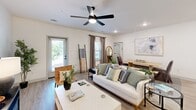 Located at 91 Wiltons Way in Bluffton, SC, this well-designed single-floor home offers two bedrooms and two full bathrooms across a comfortable, efficiently laid-out floor plan. The open-concept living and kitchen area forms the heart of the home, featuring light hardwood-style flooring, recessed lighting, and ceiling fans throughout. The kitchen is appointed with shaker-style cabinetry, stainless steel appliances including a French door refrigerator and electric range, white quartz countertops, and a striking navy blue island with pendant lighting and bar seating — a functional and eye-catching centerpiece. The living room is bright and airy, with direct access to the outdoors via a glass door that fills the space with natural light. The primary bedroom includes a ceiling fan, large window with outdoor views, and a dedicated closet. The second bedroom mirrors this comfort with multiple windows, a ceiling fan, and its own closet. Both bathrooms feature clean white subway tile tub-and-shower combinations with brushed nickel fixtures and vanities with white countertops. The overall aesthetic is modern coastal — crisp, neutral tones accented with thoughtful design details that create a calm, welcoming atmosphere throughout.