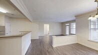 Located at 6000 Scarlet Sky Ln in Cary, NC, this 2-bedroom, 2-bathroom single-floor residence offers a well-designed layout with a comfortable, functional feel throughout. The open-concept living and dining area is defined by elegant crown molding, smooth ceilings, and durable hardwood-style flooring that flows seamlessly through the main living spaces. Natural light filters in through multiple windows, complementing the neutral, warm color palette. A dedicated kitchen features white shaker-style cabinetry with brushed nickel hardware, light countertops, and stainless steel appliances including a refrigerator, electric range, over-the-range microwave, and pantry for additional storage. The spacious primary bedroom includes a ceiling fan, generous walk-in closet with wire shelving, and direct access to a well-appointed bathroom. The bathrooms are finished with white vanities and a tub-shower combination. A dedicated laundry room houses a full-size washer and dryer. With five closets total, storage is abundant throughout. A private balcony extends the living space outdoors. The hallway and utility areas are thoughtfully integrated, completing a practical and polished single-level home.